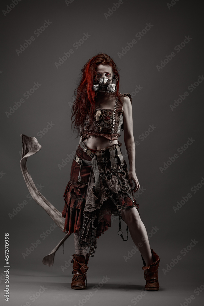 Attractive young woman with red eyes wearing post apocalyptic clothing and a gas mask Attractive young woman with red eyes wearing post apocalyptic clothing and a gas mask