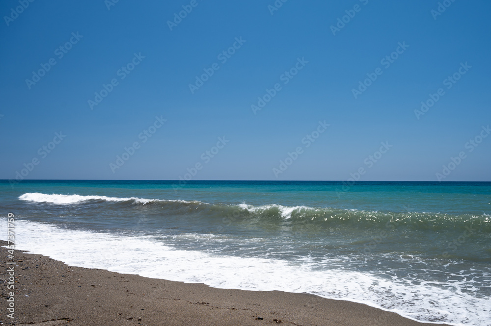 Beautiful calm beach and cloudless blue sky with ocean at low tide, with Wish You Were Here vacation greeting sample text.