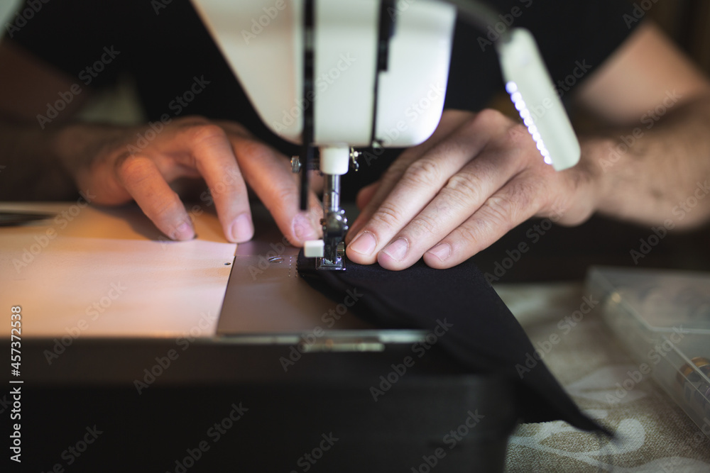 A tailor's hands at work on his sewing machine A tailor's hands at work on his sewing machine