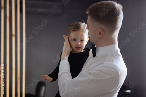 Dad adjusts his daughter's hair photo