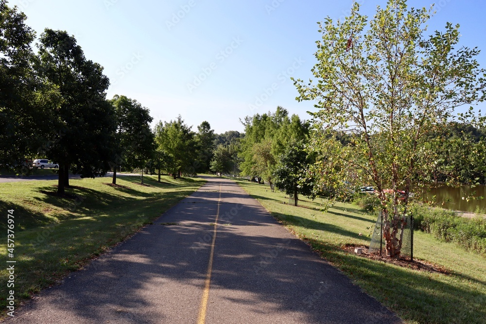 The long empty pathway in the park on a sunny day.