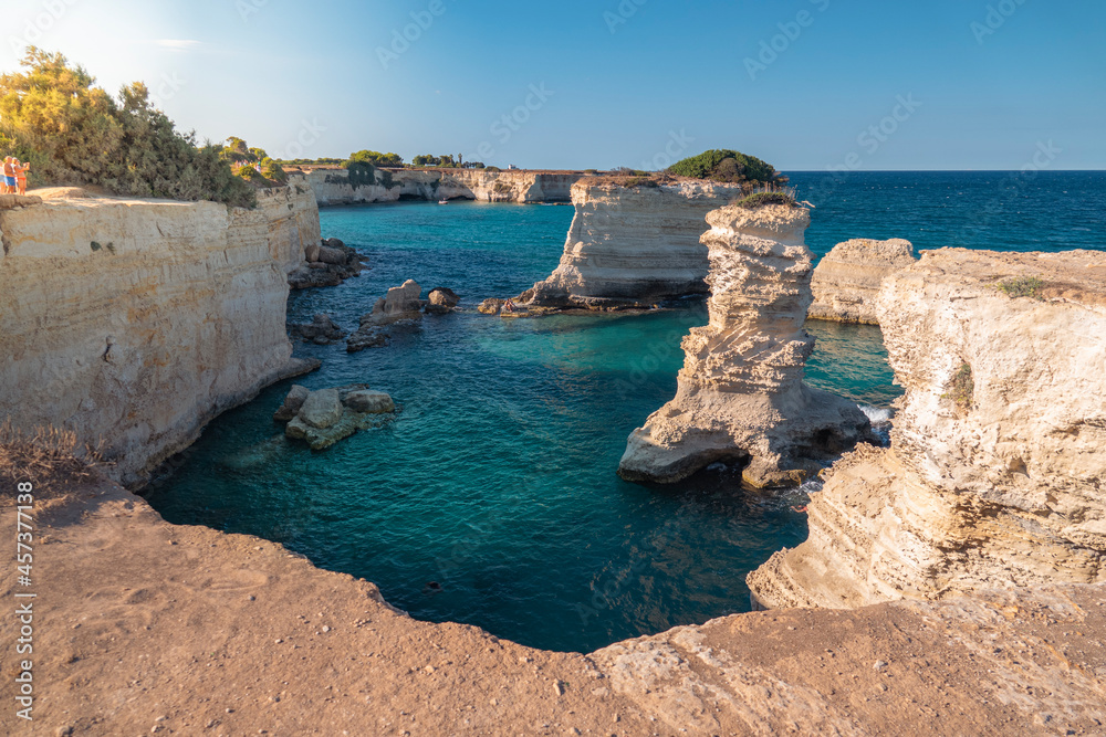 Faraglioni di Sant'Andrea (Lecce - Puglia). Agosto 2021. Scogliere al tramonto con bagnanti e turisti