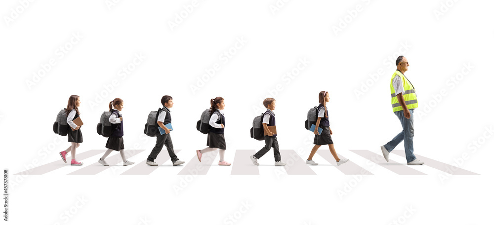 Man wearing a safety vest and leading schoolchildren across a street on a crosswalk