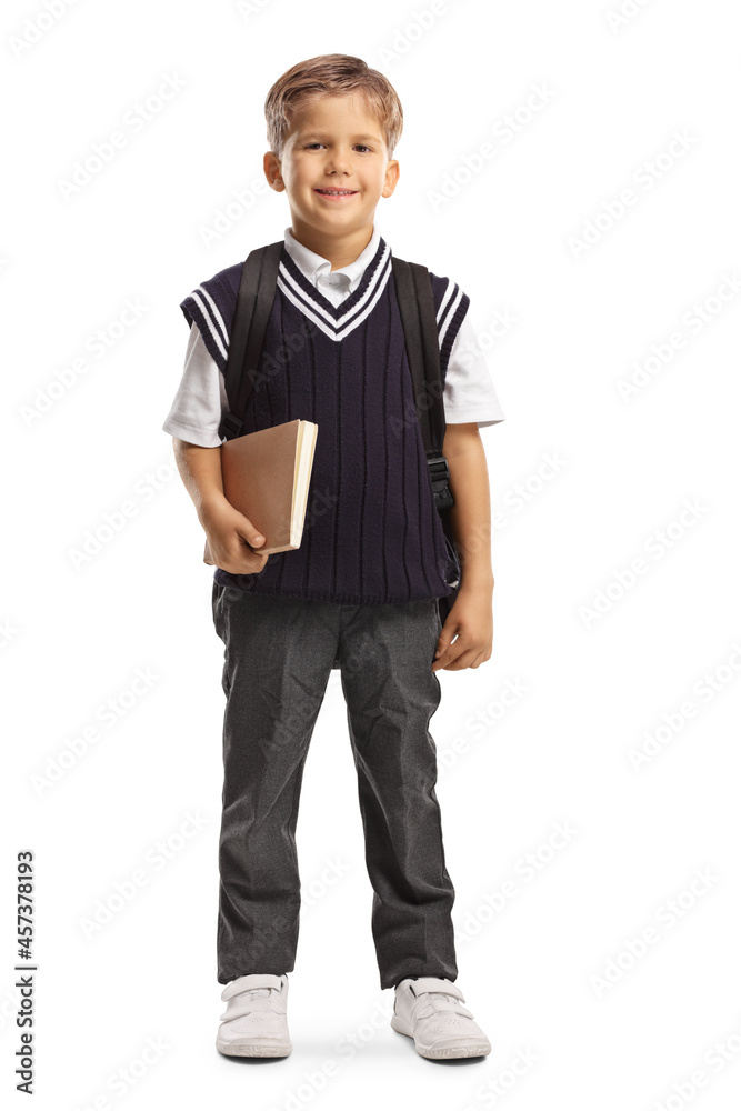 Full length portrait of a cute little schoolboy in a uniform holding a book and smiling Full length portrait of a cute little schoolboy in a uniform holding a book and smiling