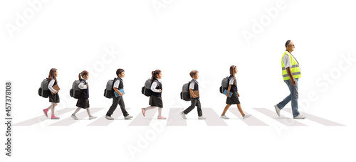 Man wearing a safety vest and leading schoolchildren across a street on a crosswalk © Ljupco Smokovski