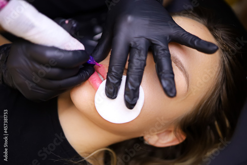 the tattoo artist presses a cotton sponge to the client s lip so that the tattoo pigment does not spread and performs a lip tattoo