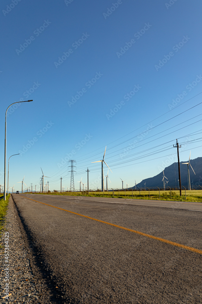 General view of wind turbines in countryside landscape with cloudless sky