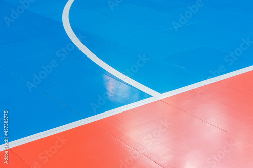 Blue and orange floor volleyball, basketball, badminton, futsal, handball court. Wooden floor of sports hall with marking lines line on wooden floor indoor, gym court