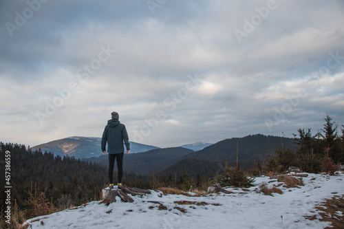 Absorbing the immense gift of nature with a lungful of fresh air and enjoying the momentary calm. A man stands on a stump looking out over the valley. Beskydy mountains photo