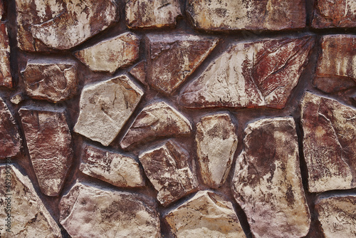 Tidy inlaid stone wall forming a decorative residential pattern