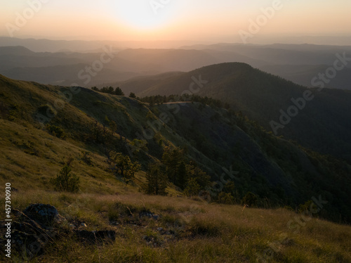 View of the slopes of the mountain Ozren from the peak Gostilj  a landscape of hilly Balkans with haze on the horizon at sunset