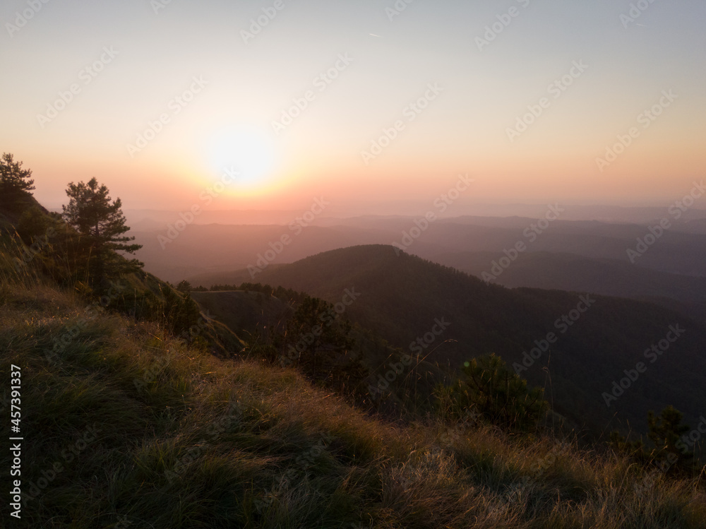 View of the slopes of the mountain Ozren from the peak Gostilj, a landscape of hilly Balkans with haze on the horizon at sunset