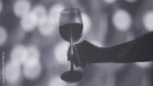 Shadow of hand holding a wine glasse photo