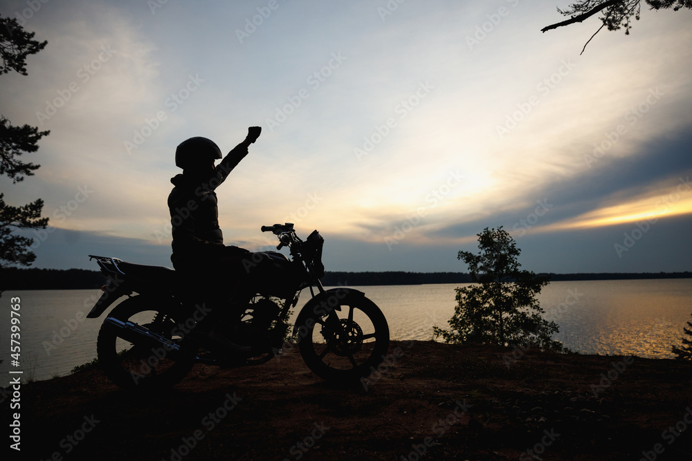 Fototapeta premium silhouette of a girl on a motorcycle at sunset