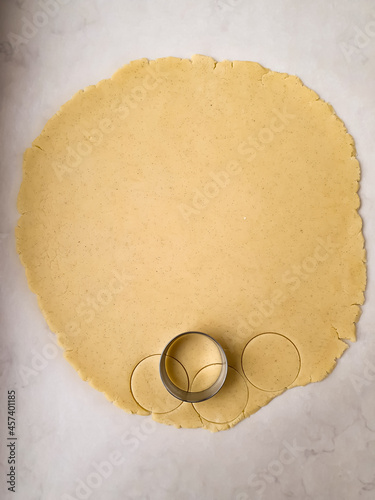 Canvas Print Roll out the dough and cut with a roung metal cookie cutter top view