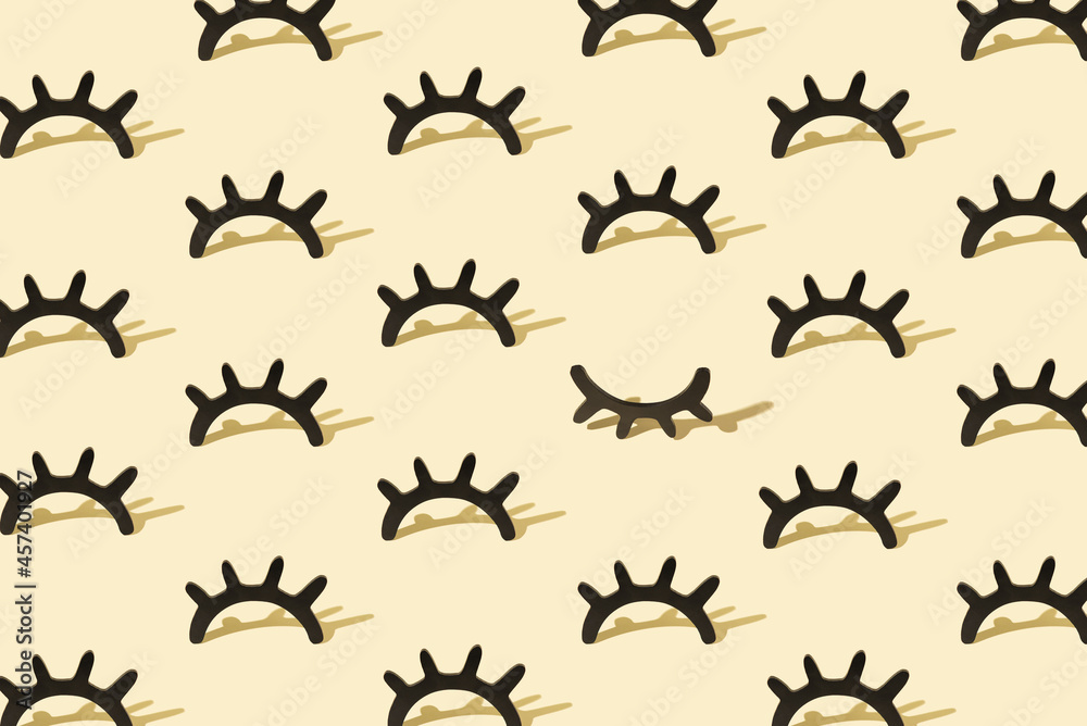 Fototapeta premium Creative pattern with wooden eyelashes on a pastel yellow backgr