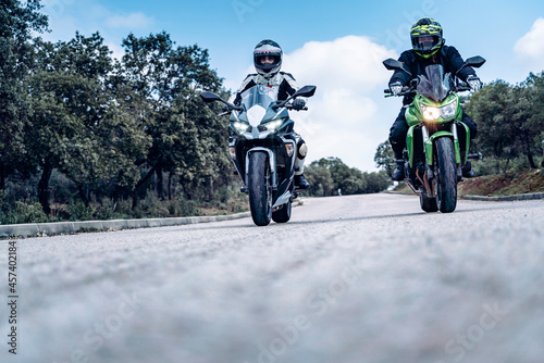 biker couple riding along a mountain road with their sport bikes