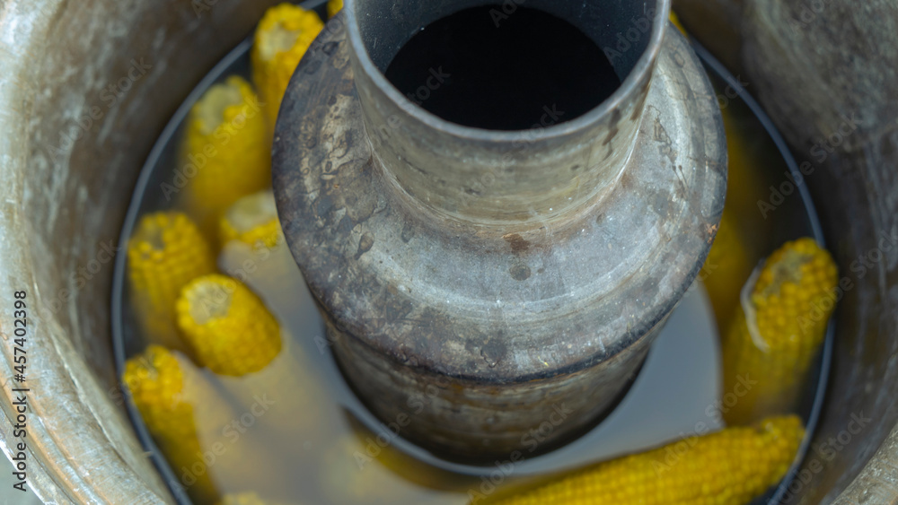 Yellow corn cooked in a tradition russian samovar. Life hack. A conceptual approach to cooking street food. Yellow corn cooked in a tradition russian samovar. Life hack. A conceptual approach to cooking street food.