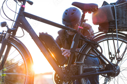 man changing electric bicycle battery photo