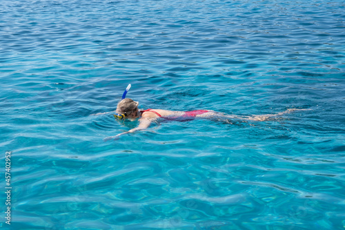 woman swimming in sea with snorkel