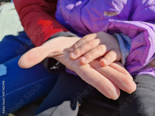 The Baby girl and mom hands close-up. Mom strokes the hand of the child. © Binkontan