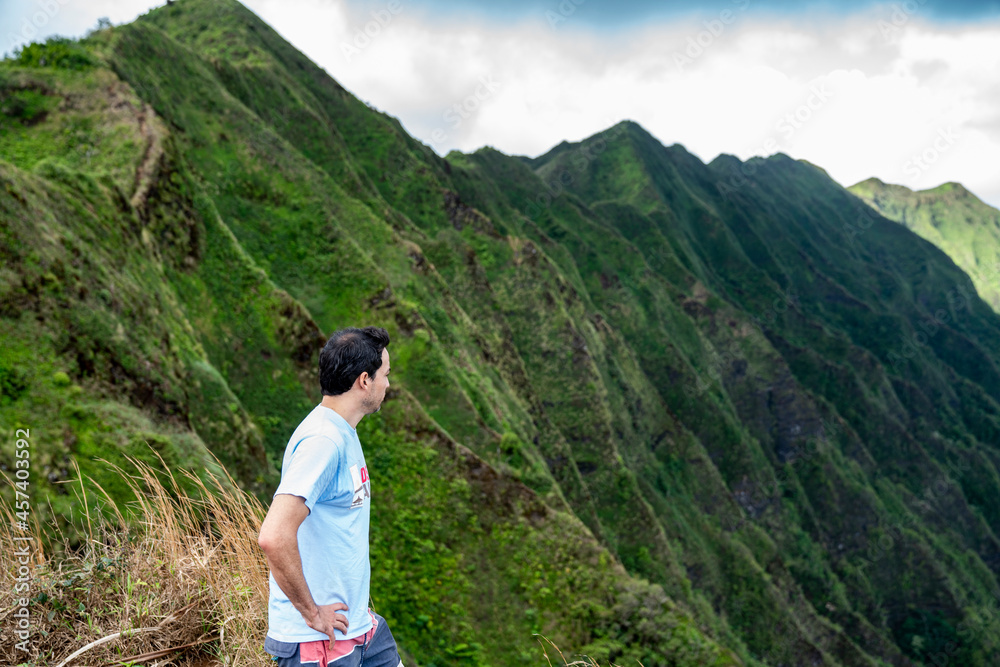 Brunette man overlooking a mountain range in Hawaii