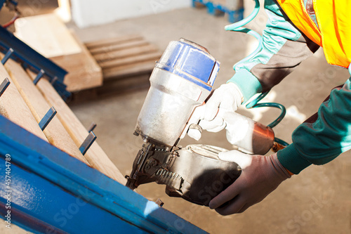 Vászonkép Professional furniture production factrory worker using pneumatic hammer