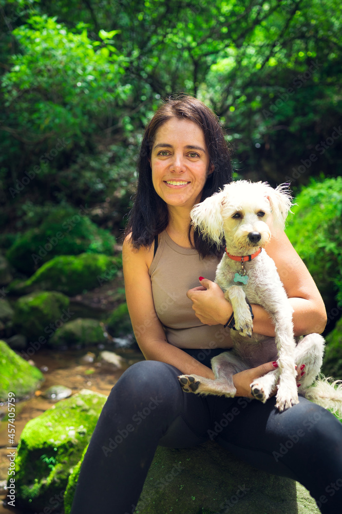 Young woman posing with her puppy in the tropical forest. Woman and pet in green wet forest on sunny day. Sustainable tourism concept. Amatlán, Mexico. Young woman posing with her puppy in the tropical forest. Woman and pet in green wet forest on sunny day. Sustainable tourism concept. Amatlán, Mexico.