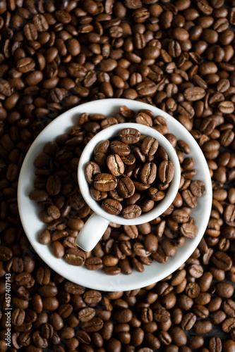 Cup with coffee beans on coffee beans background