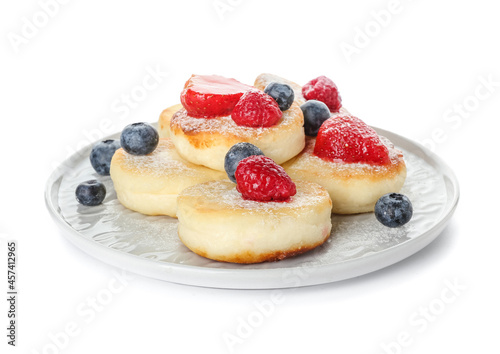 Plate with tasty cottage cheese pancakes and berries on white background