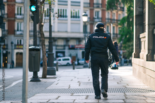 Policewoman member of the Spanish security forces and bodies walking down a city street photo