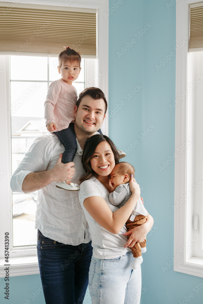Happy family with two little children at home. Ethnic diversity.
