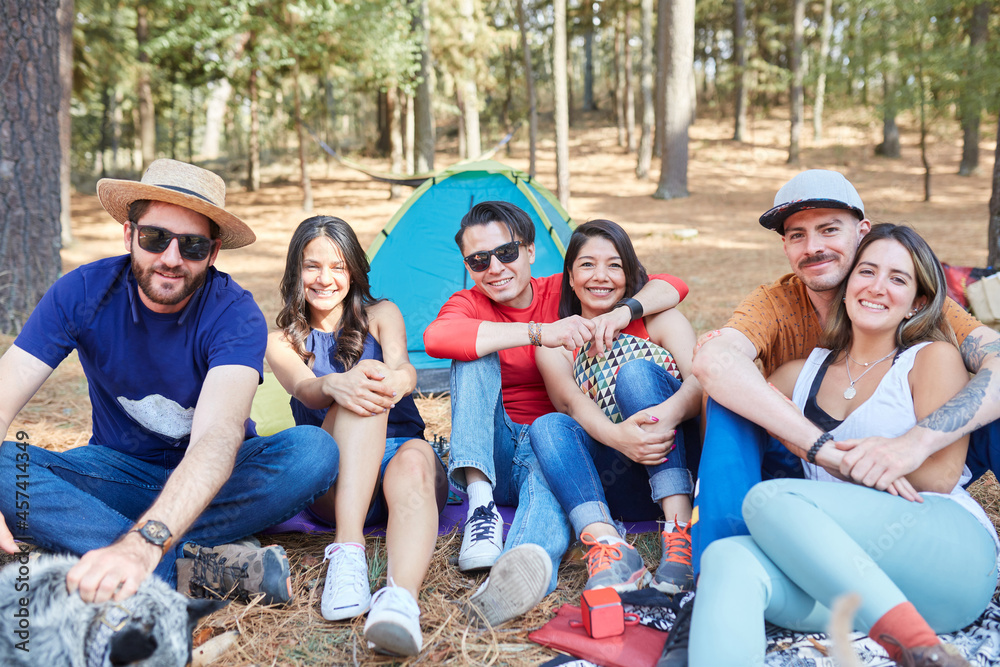 group of friends having a nice time outside their tent group of friends having a nice time outside their tent