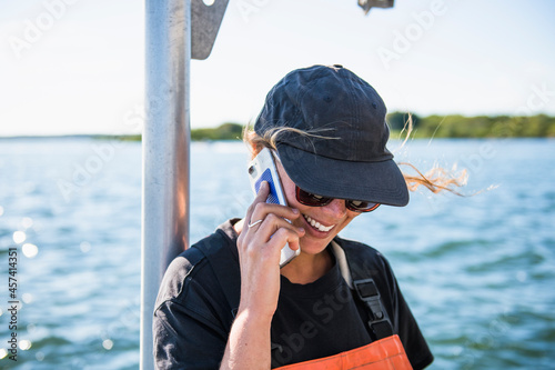 Woman on Phone while working on the water in aquaculture oyster farm photo