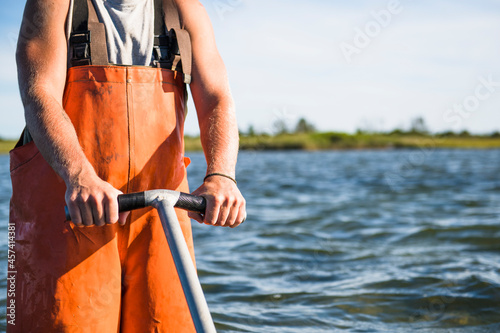 Young man working on the water in aquaculture oyster farm photo