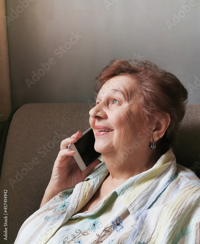 Elderly woman talking on cell phone smiling happily photo