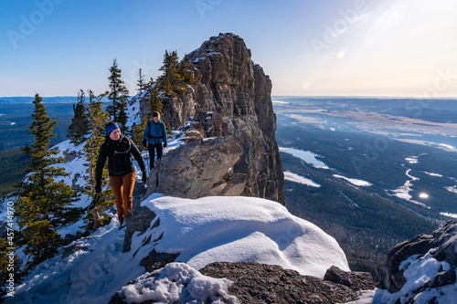 Two Female Friends Scrambling Rocky Mountains During Sunrise photo