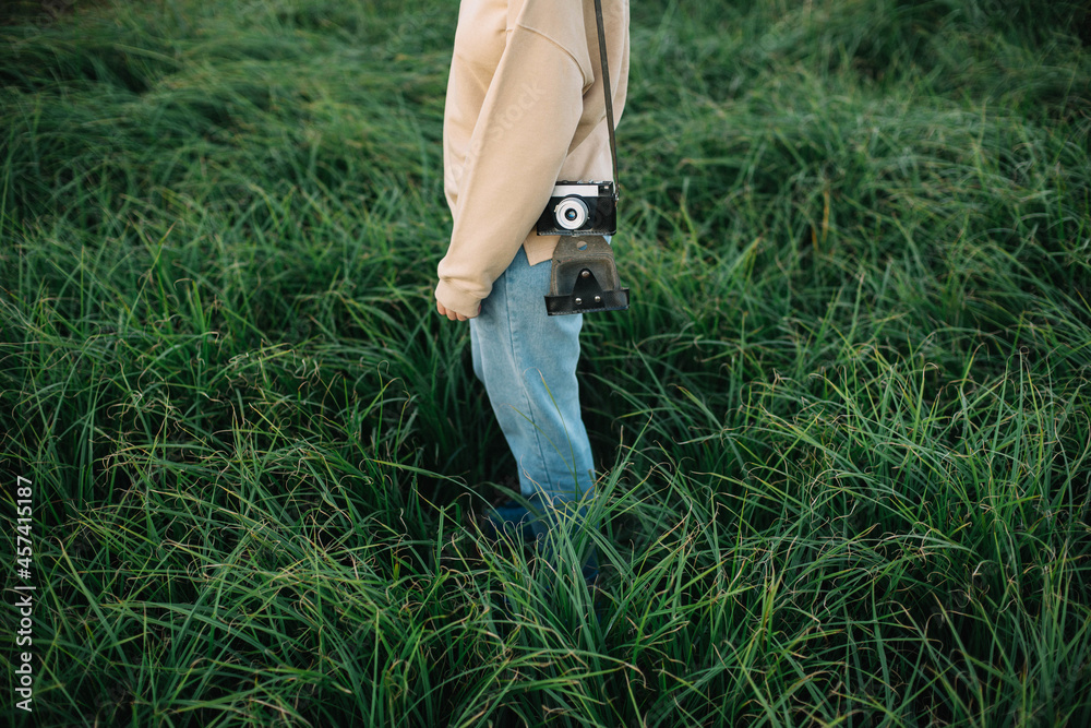 Pretty woman holding film camera in a field Pretty woman holding film camera in a field