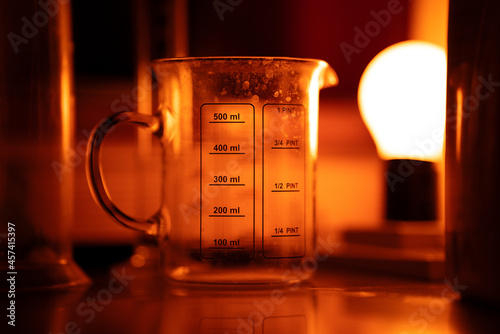 A calcified measuring cup in red light, which is part of a film processing kit
