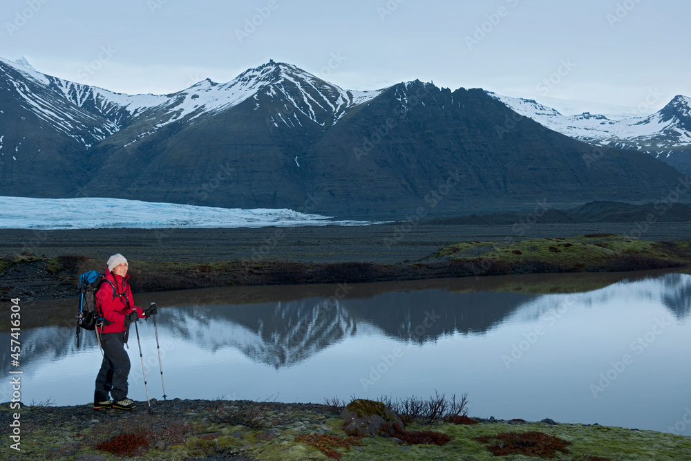 female hiker trekking through barren landscape in Skaftafell / Iceland female hiker trekking through barren landscape in Skaftafell / Iceland