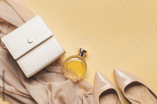 Stylish female accessories on yellow background