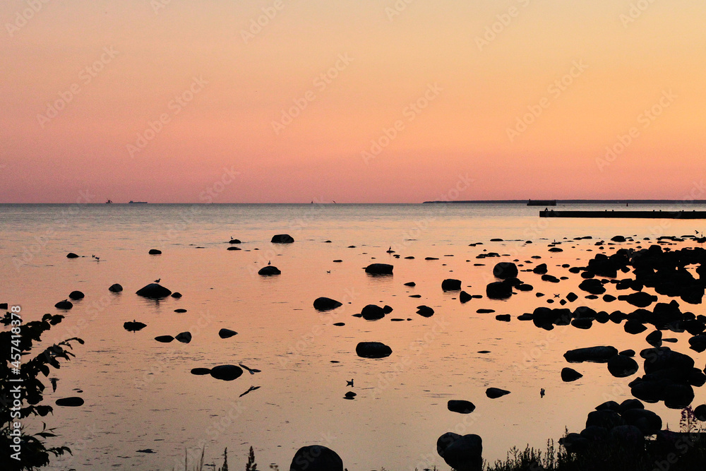 Azure water with stones of a Baltic sea on a sunset