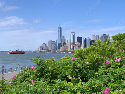 Downtown Manhattan with Staten Island ferry behind the green of Governor Island
