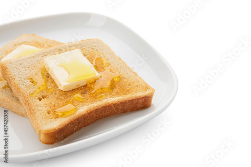 Plate with delicious toasted bread with honey and butter on white background, closeup