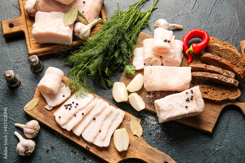 Boards with salted lard and bread on dark background photo