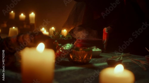 Witch woman sitting in pentagram circle and cooking potion. Evil sorceress making rite and sacrifices at night, using black witchcraft, cow skull and candles on floor. Halloween tradition, usa holiday