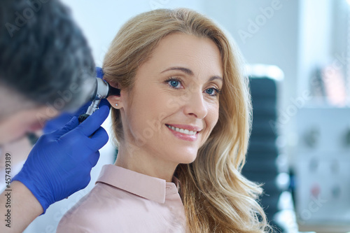 Long-haired woman and otolaryngologist examining ear