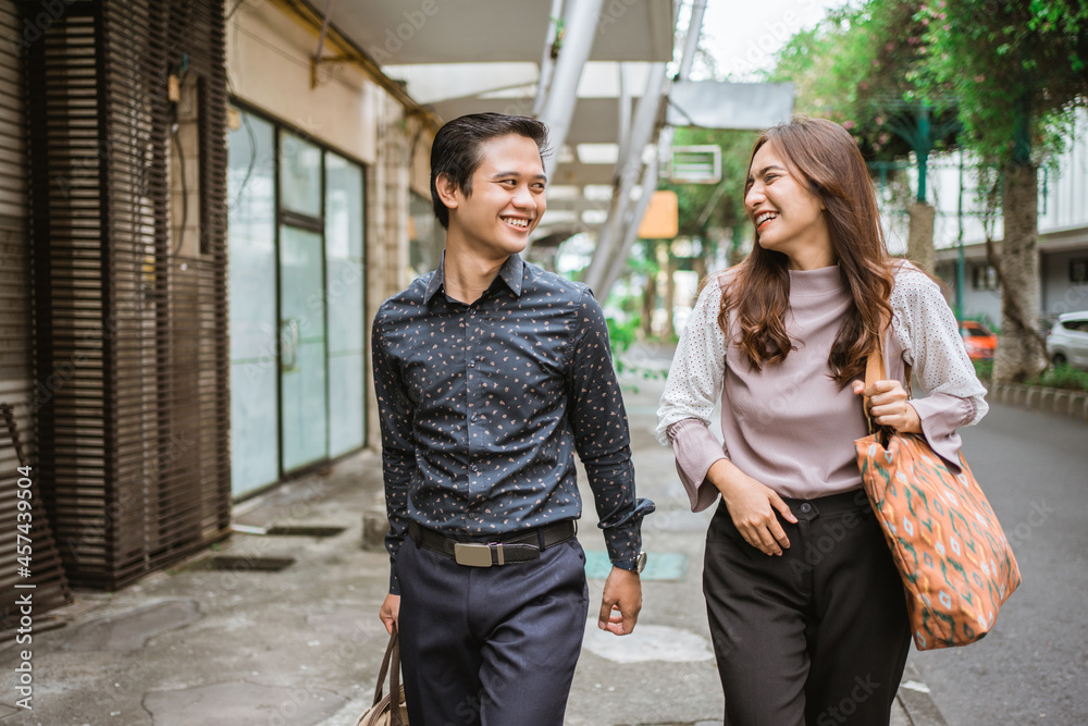 Business man and woman walking trough sidewalk smiling going to office