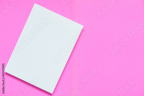 top view of blank clean white A4 paper brochure with soft shadow on light pink paper background, flat lay. © weerasak
