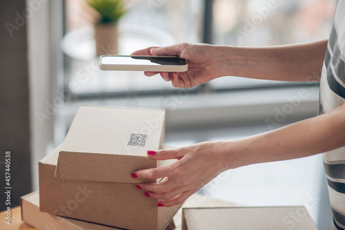 Busy young businesswoman preparing merchandise for shipping